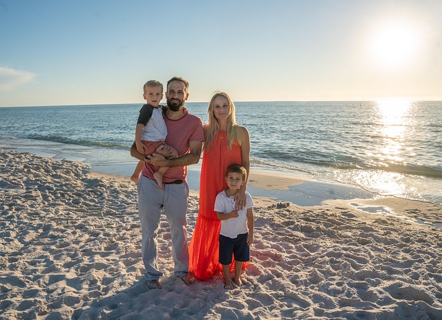 Happy family of four walking on a sunny beach, smiling, representing a perfect Serva Travel family vacation.